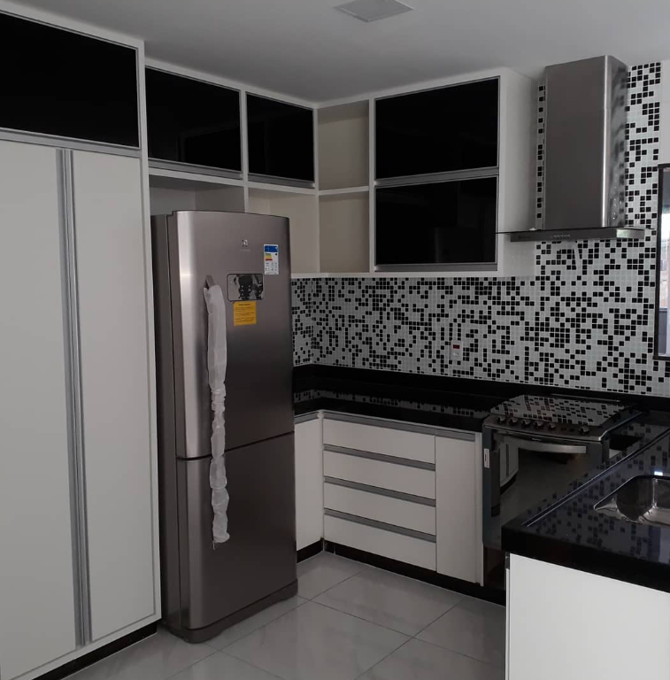 Cozinha com pastilhas e armários pretos e brancos — projeto Castro